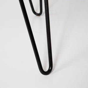 Close-up of a black hairpin leg on a white background