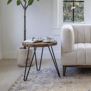 Small wooden side table with black hairpin legs next to a beige sofa in a living room.