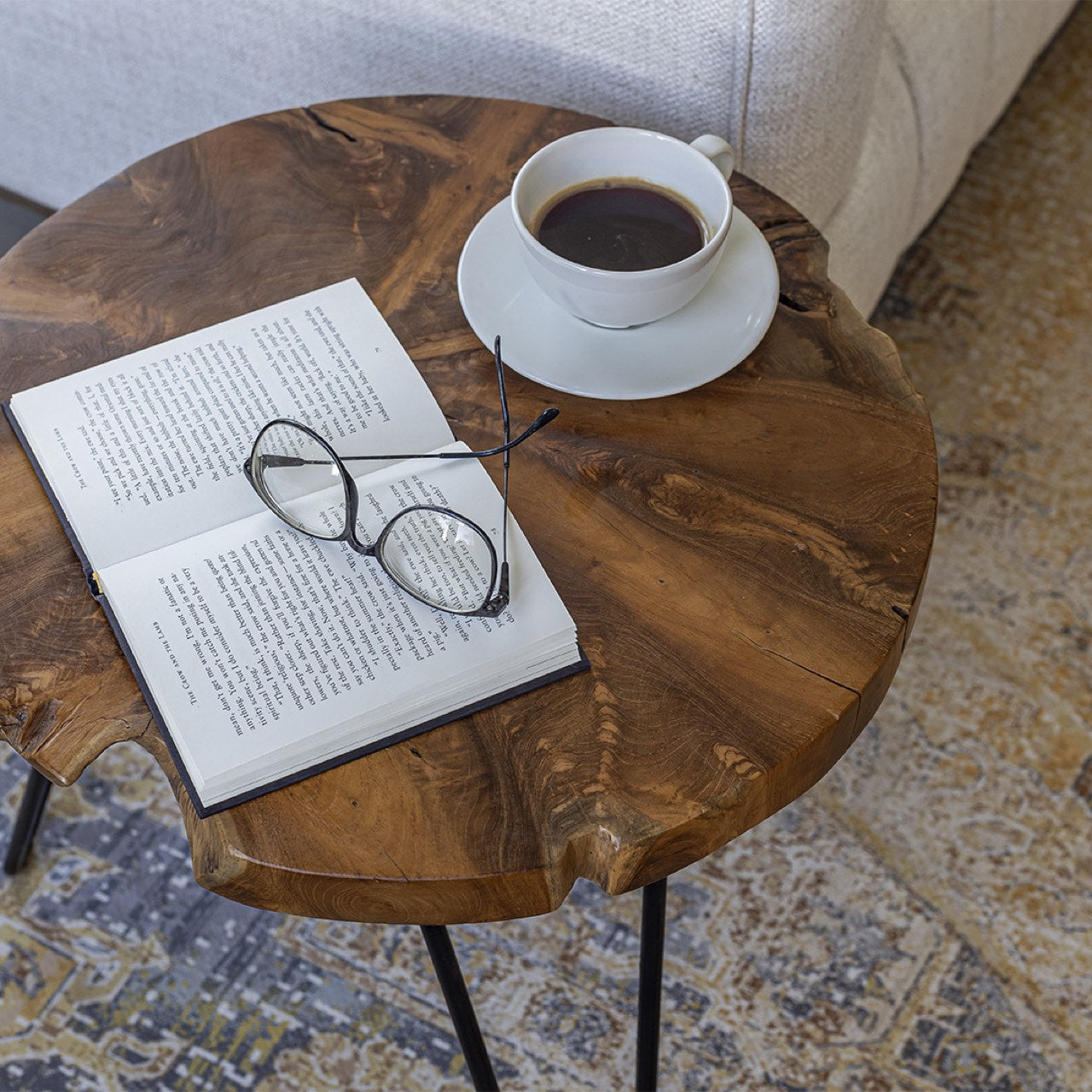 Open book with glasses and a cup of coffee on a wooden table