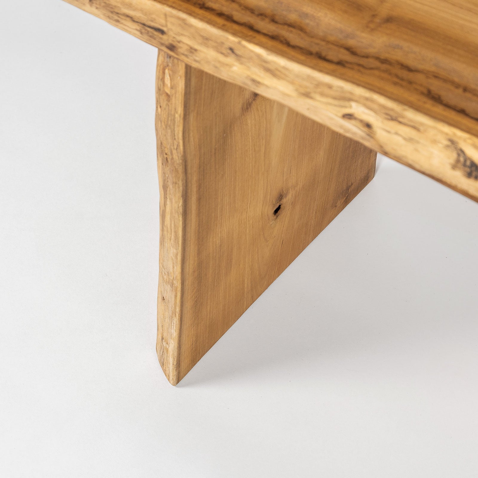 Close-up of a wooden table leg on a light gray background