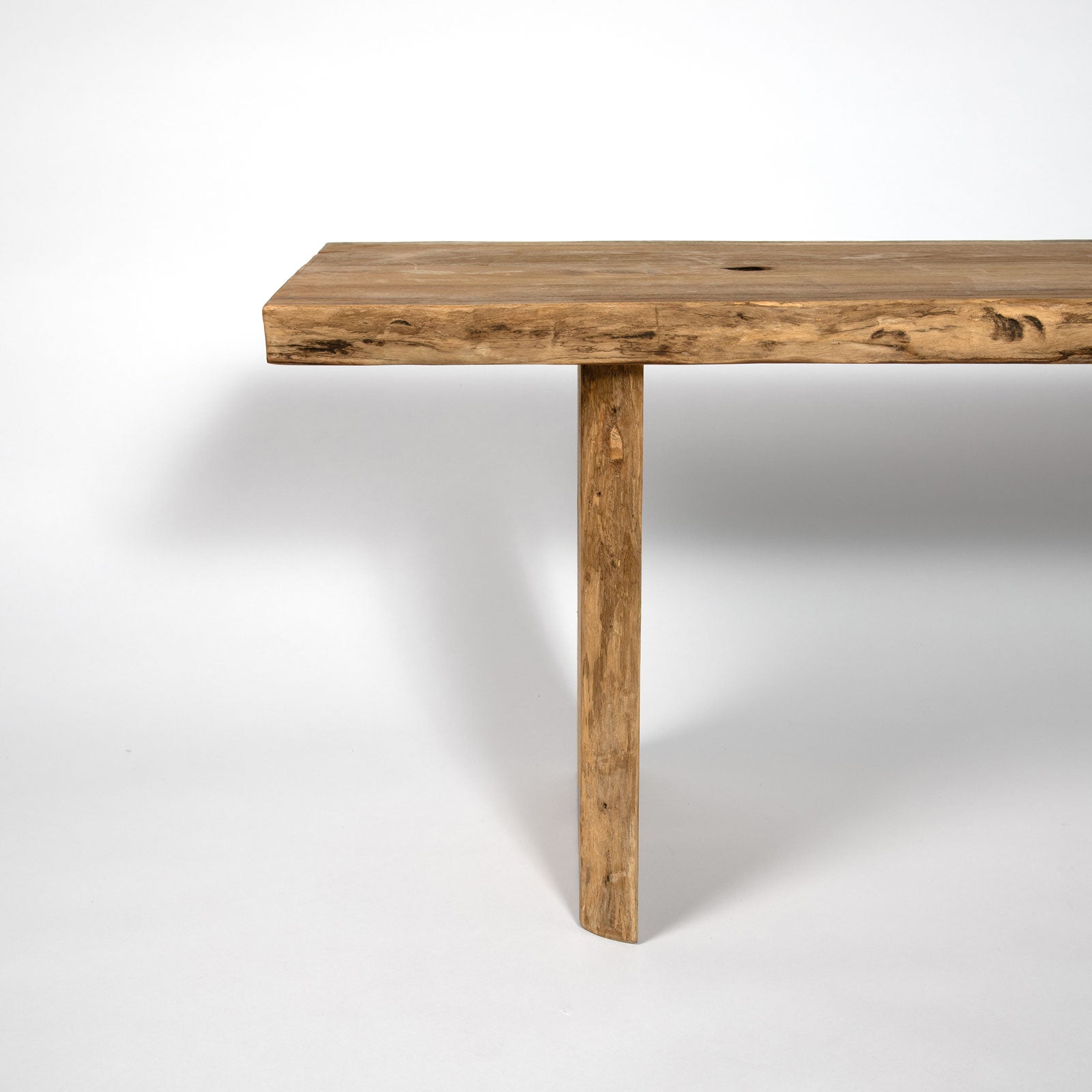 Wooden table with a single leg on a white background