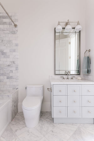 Sutton Bath And Vanity 26" in polished nickel styled in a bright bathroom for warm, layered light at Laurie Yapp Home.