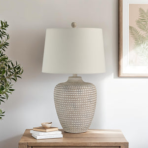 Albacete table lamp on a wooden side table, styled with books and a small dish.