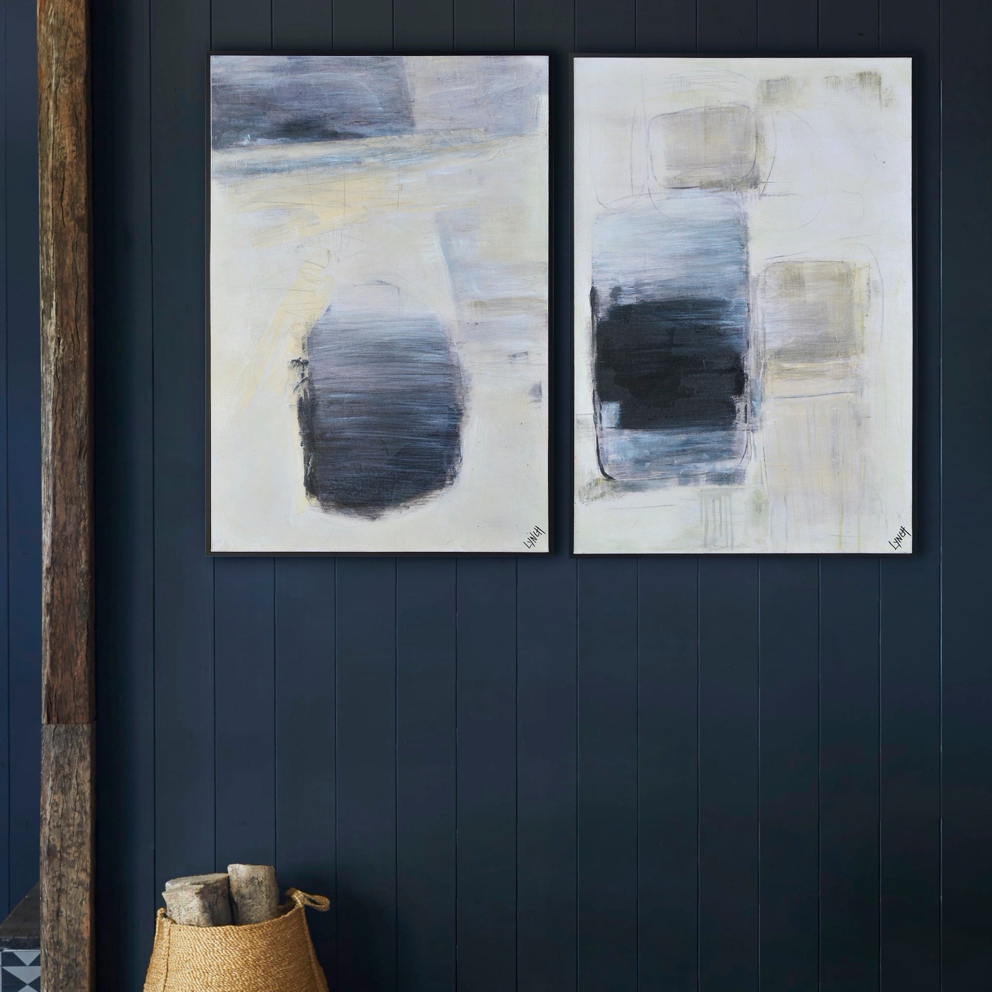 Leclaire canvas art displayed on a dark wall, featuring two pieces with abstract designs in blue and black.