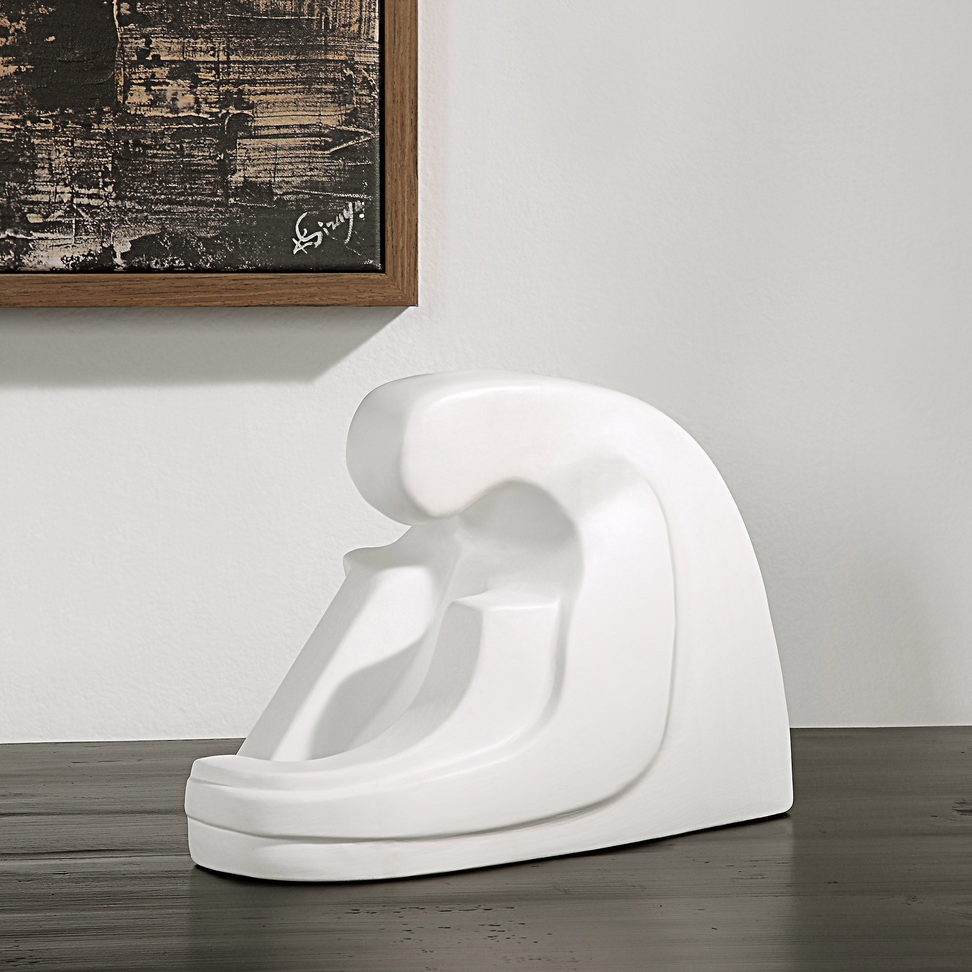 Imagine Statue by Renwil displayed on a table, with artwork in the background.