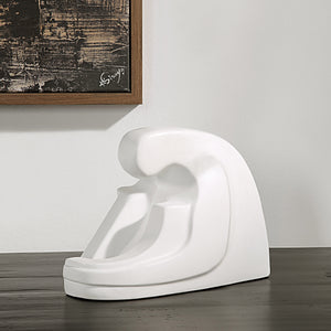 Imagine Statue by Renwil displayed on a table, with artwork in the background.