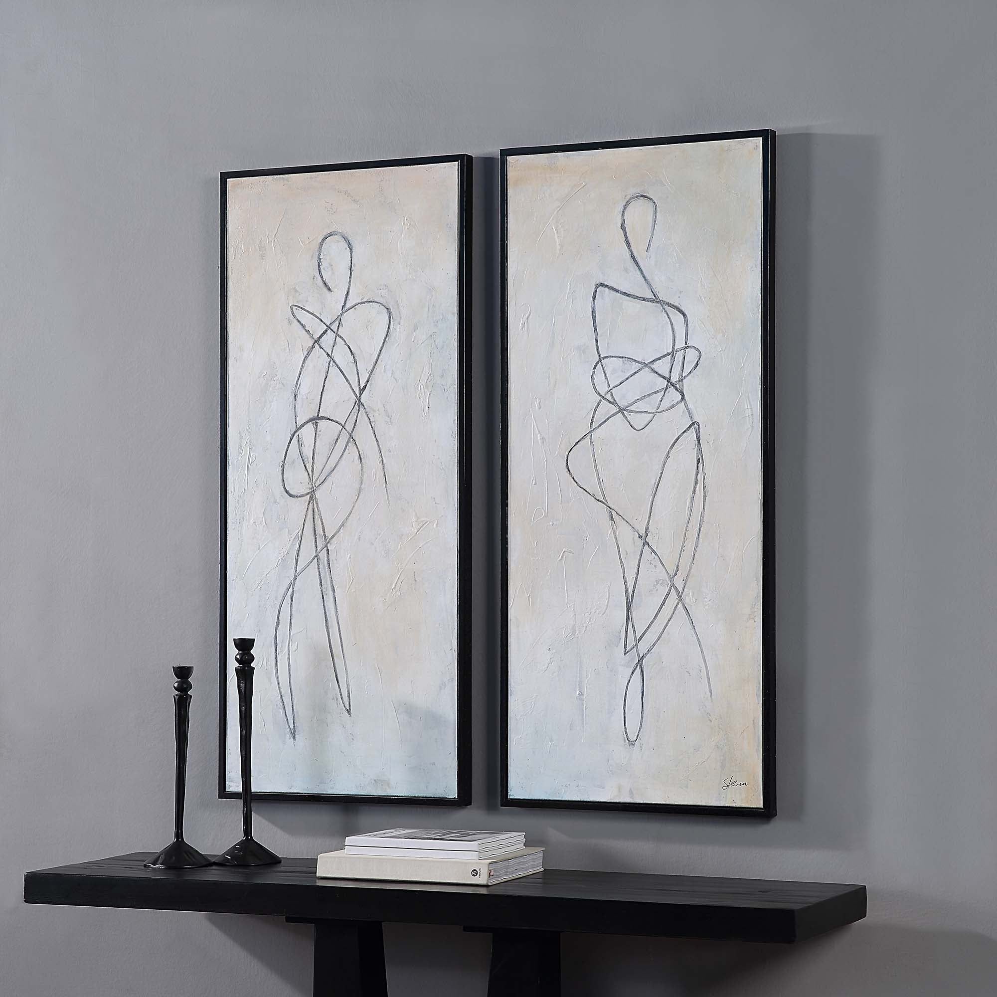 Self canvas art by Renwil displayed on a wall with black candlesticks and books on a table