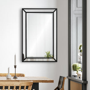 Waterloo Wall Mirror displayed in a dining area, reflecting a plant and candle on a wooden table.