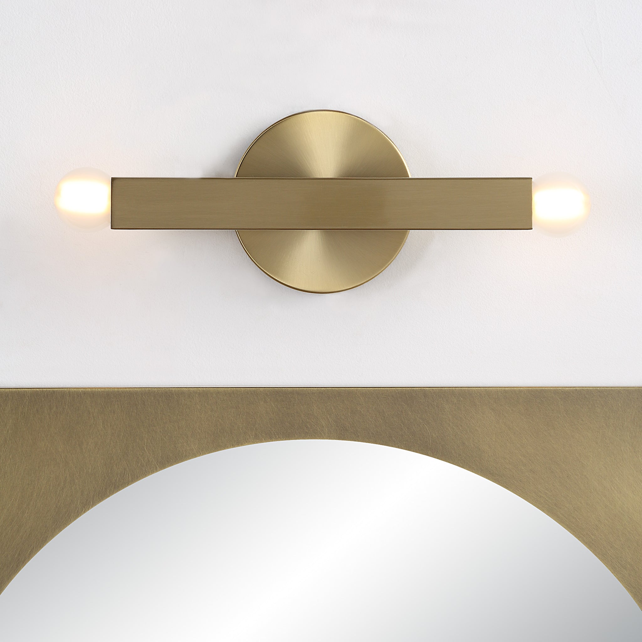 Kassie Wall Sconce mounted horizontally with two globe lights and circular backplate above a mirror