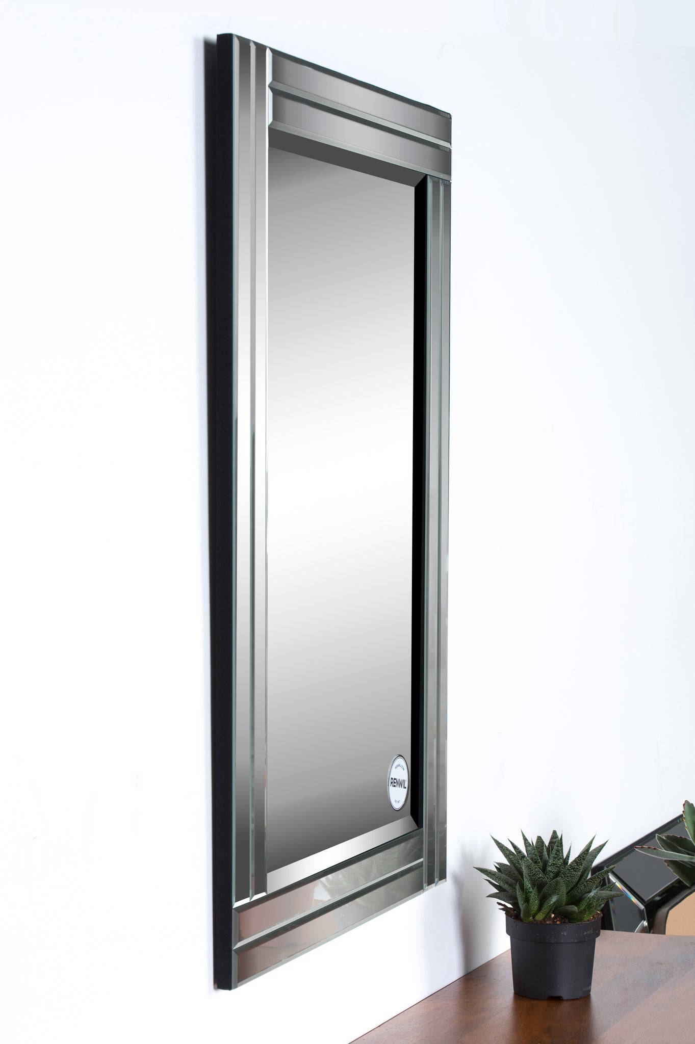 Baton Rouge Wall Mirror mounted on a wall, showcasing its stylish frame and surrounding decor.