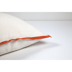 Elise Indoor Pillow featuring white fabric and orange piping, angled view