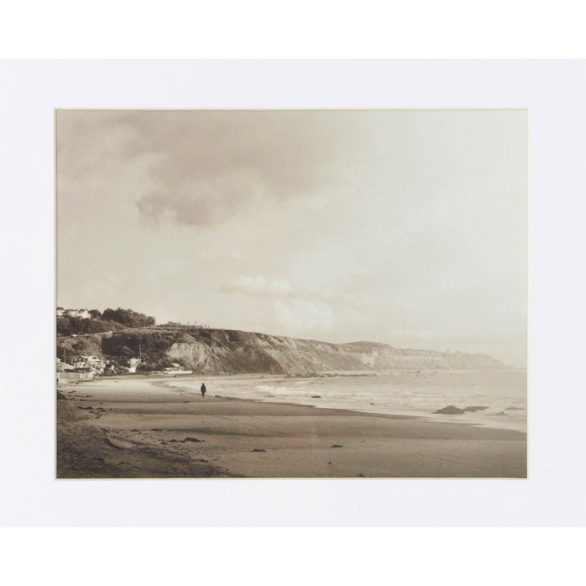 Torreys Wall Art displaying a black and white beach scene with a person walking along the shore, framed.