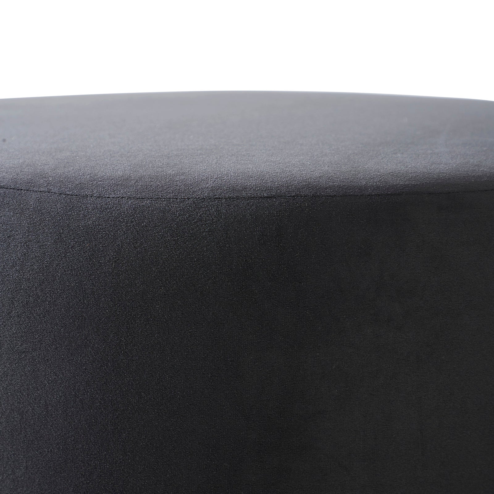 Colum Ottoman in dark gray velvet, round shape with smooth surface, angled view.