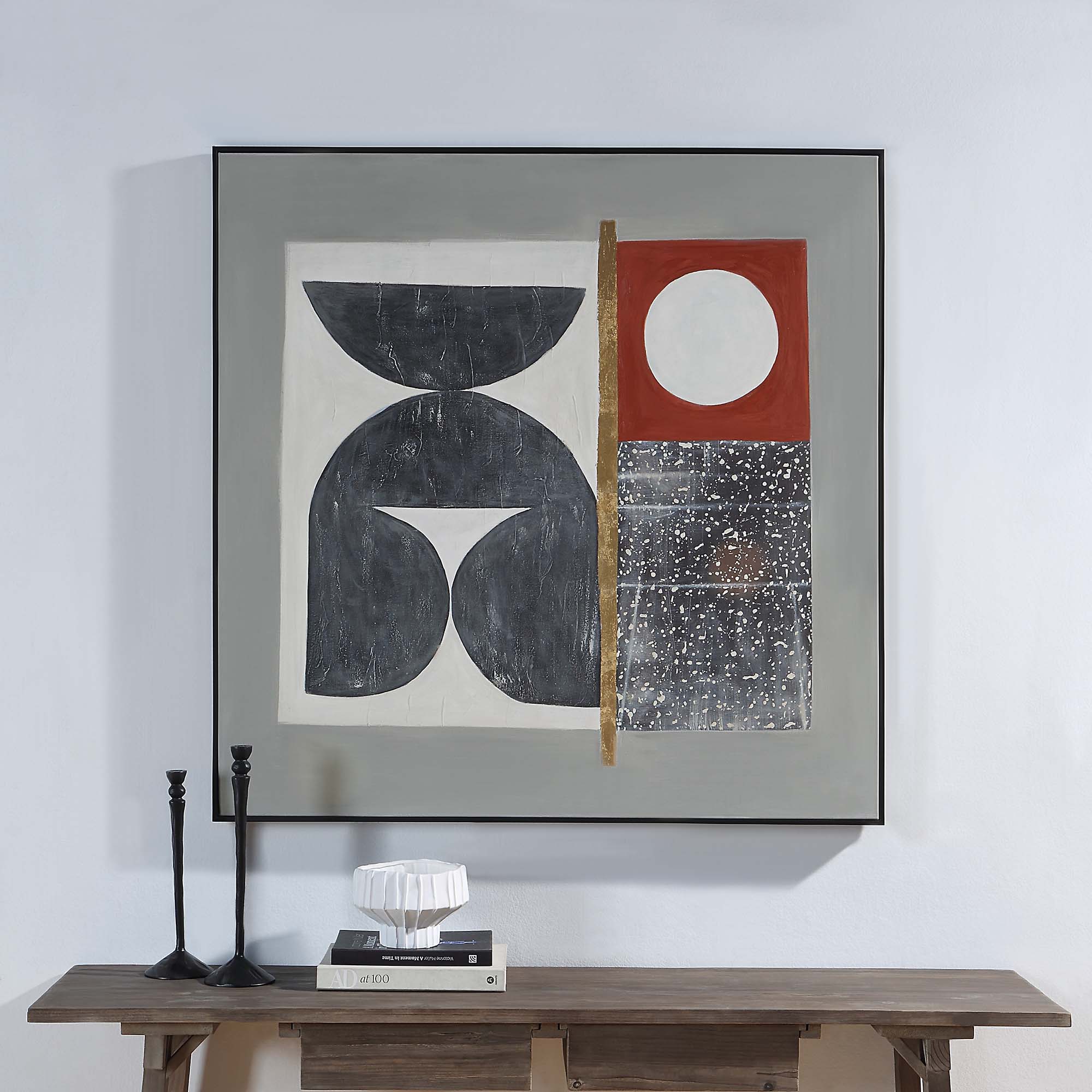 Marron canvas art displayed on a wall above a wooden table with decor items.