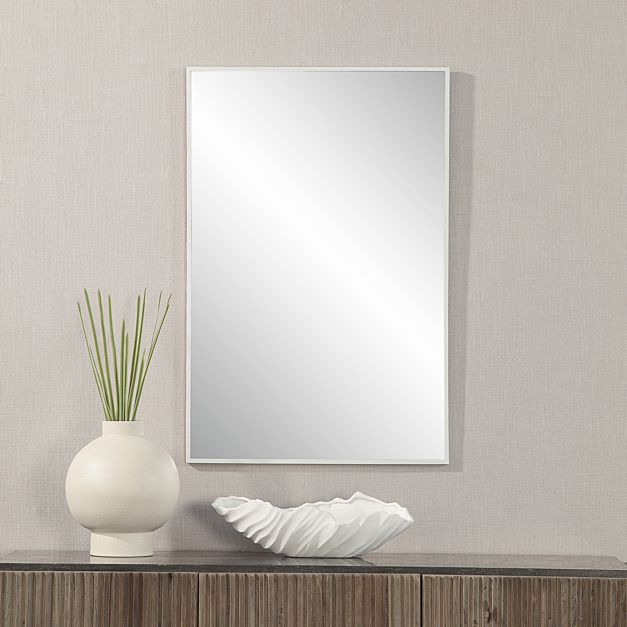 Orchid Wall Mirror displayed above a wooden table with decorative vase and bowl.