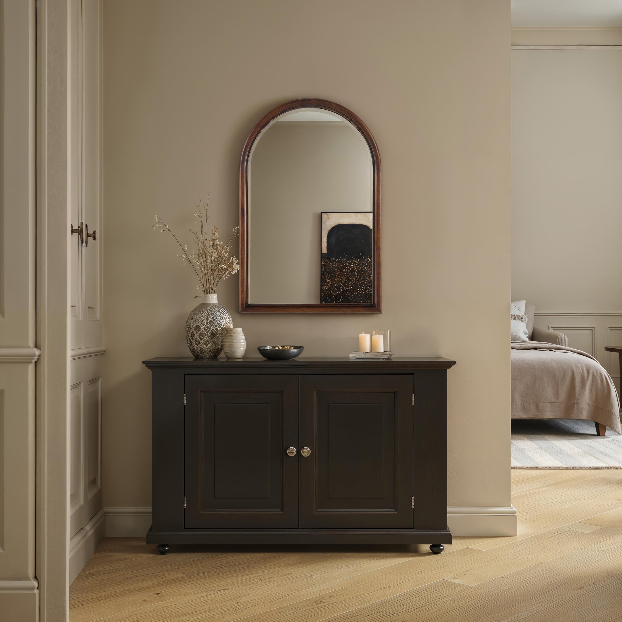 Lanai mirror displayed above a dark wooden cabinet in a softly lit room