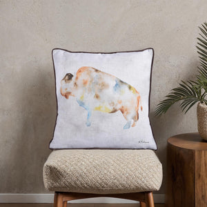 Marla Indoor Pillow displayed on a textured stool, showcasing a watercolor bison design