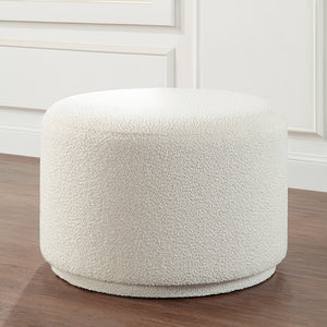 Audrina Ottoman with a soft white texture, round shape, placed in a room setting