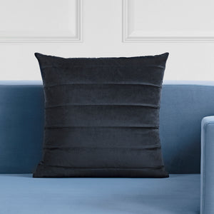 Chatra Indoor Pillow in dark gray displayed on a blue couch
