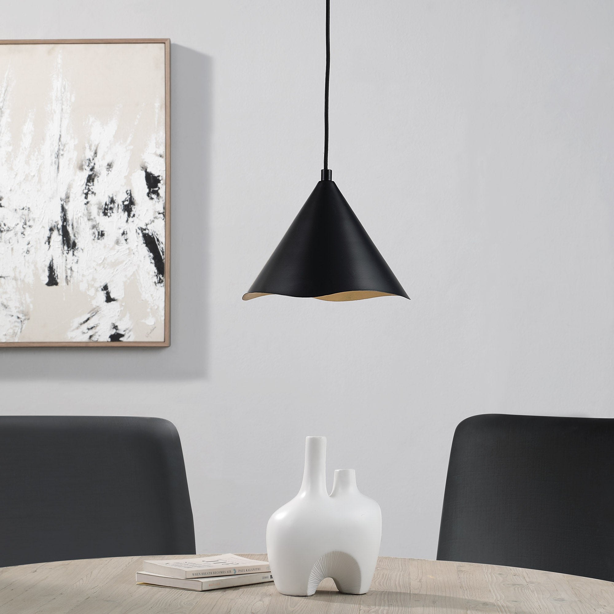 Cinder Ceiling Fixture in black above a dining table, paired with white vase and artwork on wall.