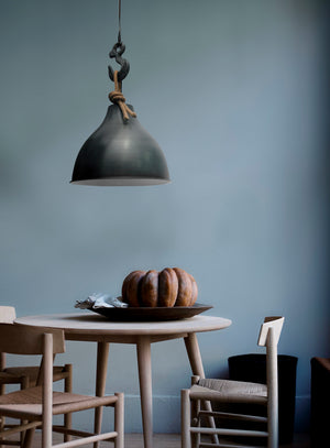 Maturin pendant light in a dining setting, showcasing a black metal shade and decorative rope.