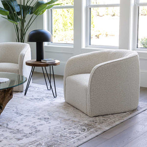 Modern living room with beige armchair, side table, and decorative lamp.
