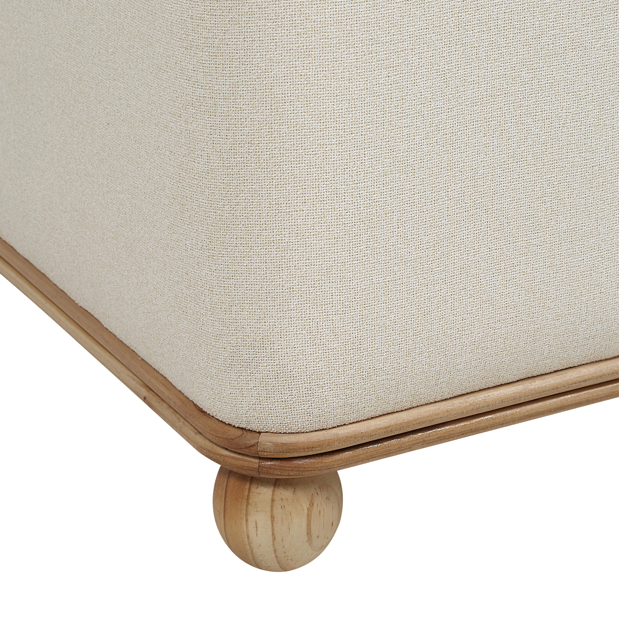 Close-up of Sines Ottoman showing light beige fabric and wooden trim