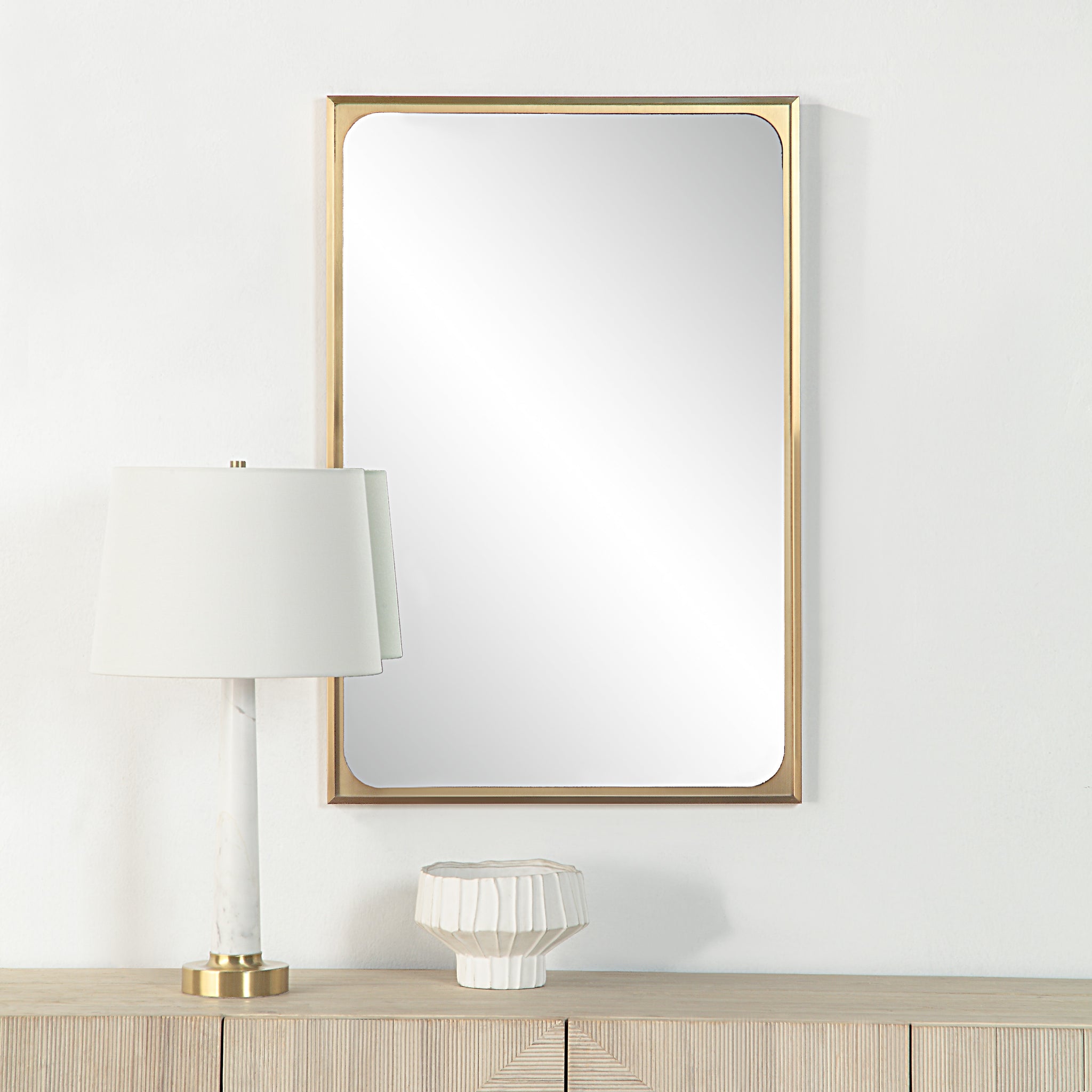 Sati Wall Mirror displayed above a wooden console, alongside a lamp and decorative vase.