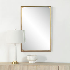 Sati Wall Mirror displayed above a wooden console, alongside a lamp and decorative vase.