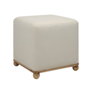 Sines Ottoman featuring light beige upholstery and wooden legs, angled view