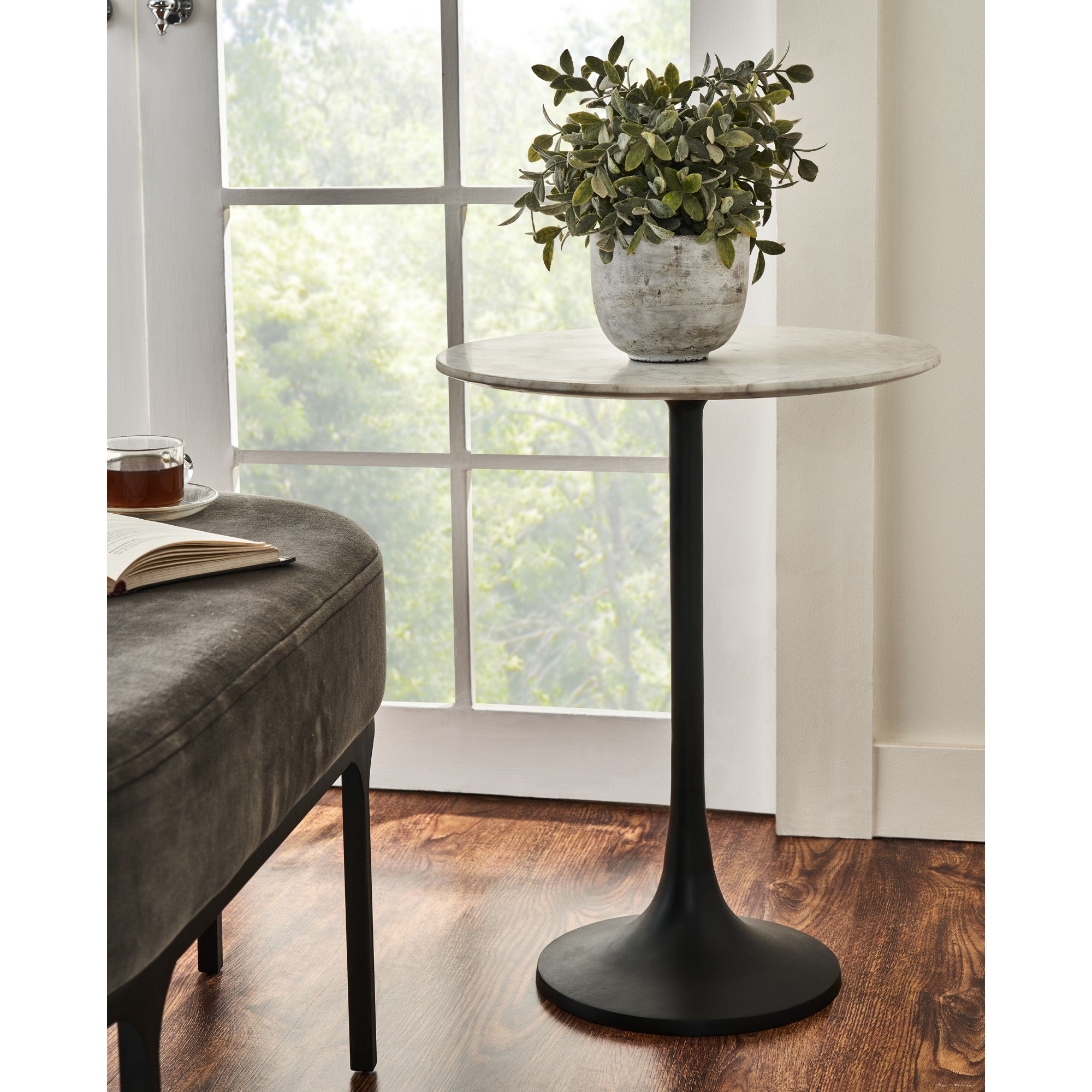 Mortain Table styled with a potted plant and a book, next to a window