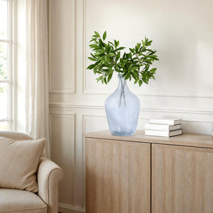 Mirabella vase by Renwil in light blue glass with green leaves, placed on a wooden cabinet.