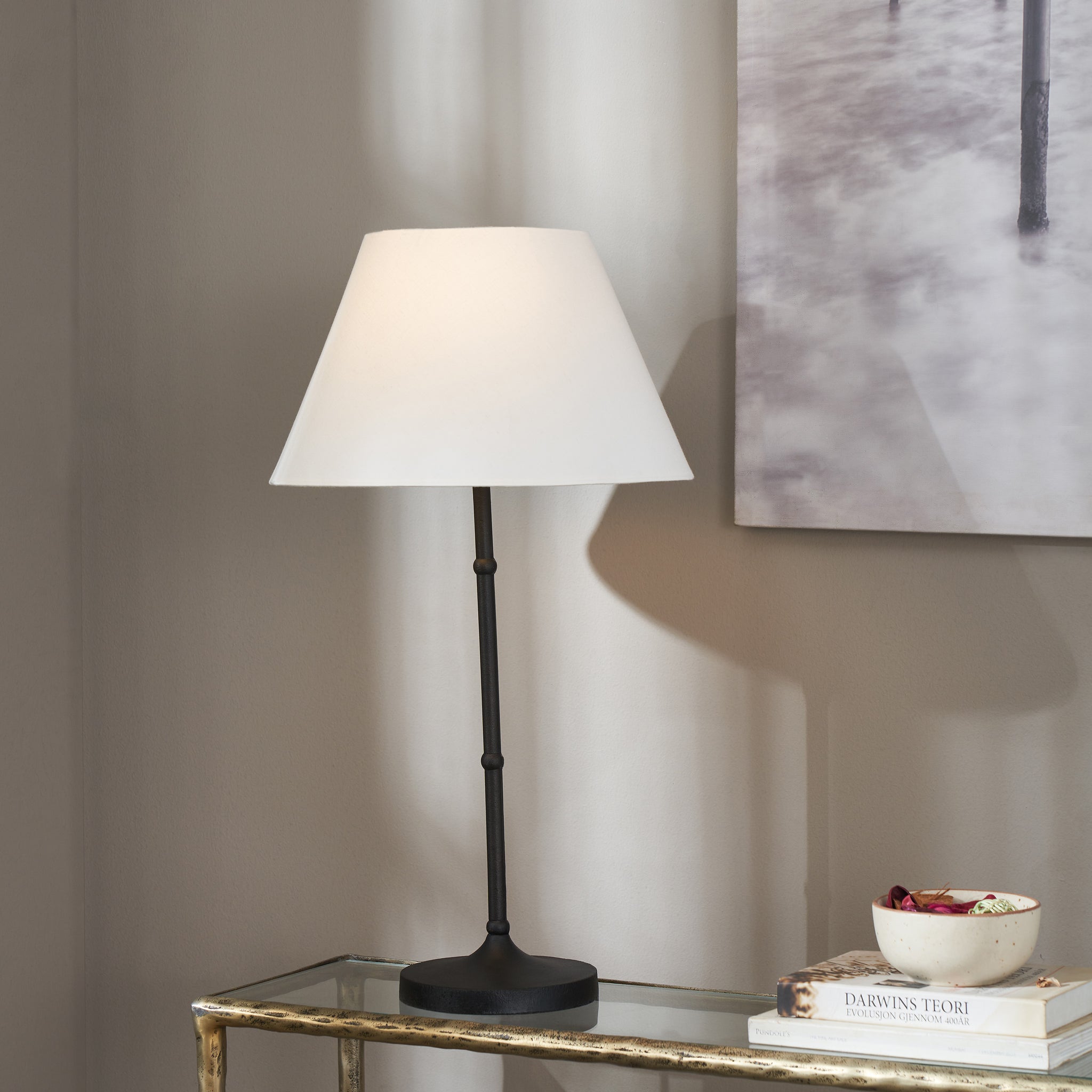 Kalista Table Lamp on a glass table, casting a soft shadow