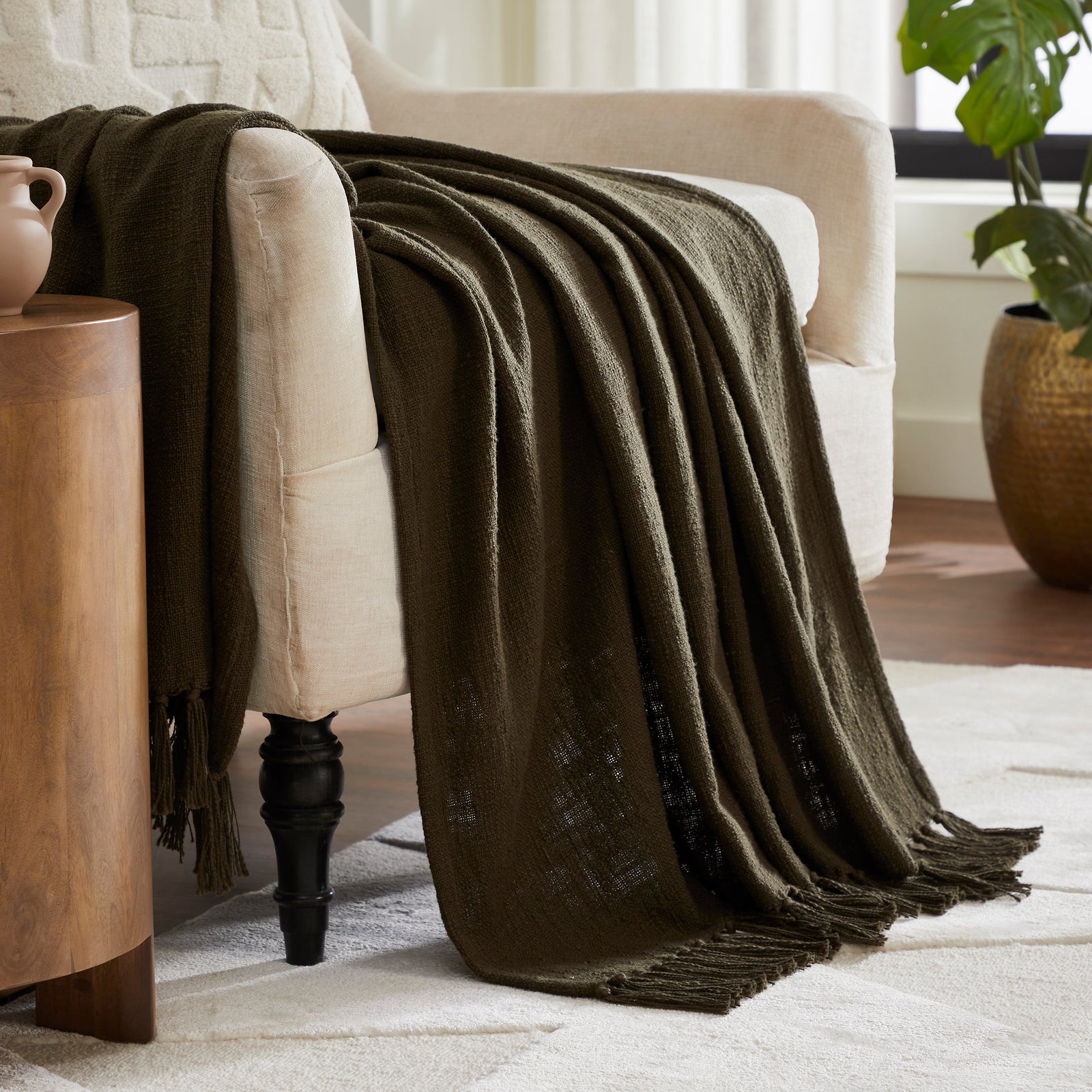 Chalamet Throw Blanket in dark green with fringed edges, flat view.