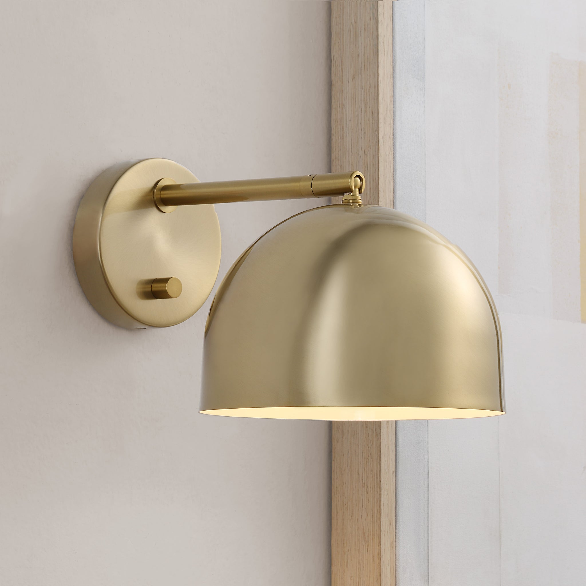 Conali Wall Sconce mounted on a wall, displaying its dome shade and brass finish.
