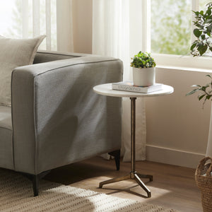Canning Side Table beside a gray sofa, featuring a plant and a book on top.