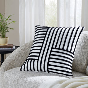 Stilo indoor pillow with a black and white striped design, placed on a cozy sofa.