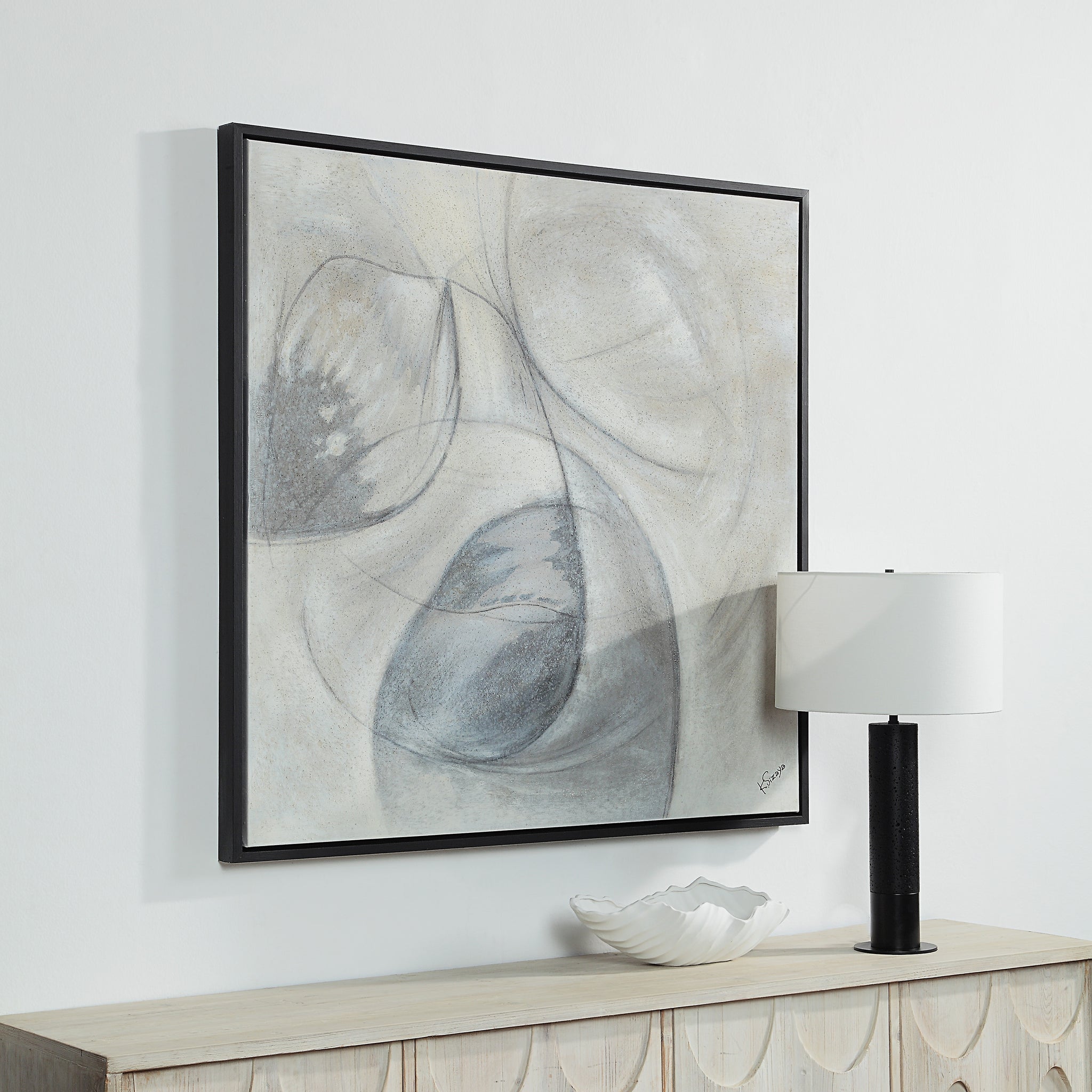 Webb canvas art hung on a wall next to a lamp and decorative bowl, featuring abstract gray and black shapes.
