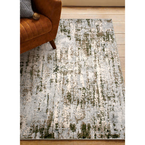 Ariella Indoor Rug in a living space, paired with a brown sofa, showcasing its gray and green design.