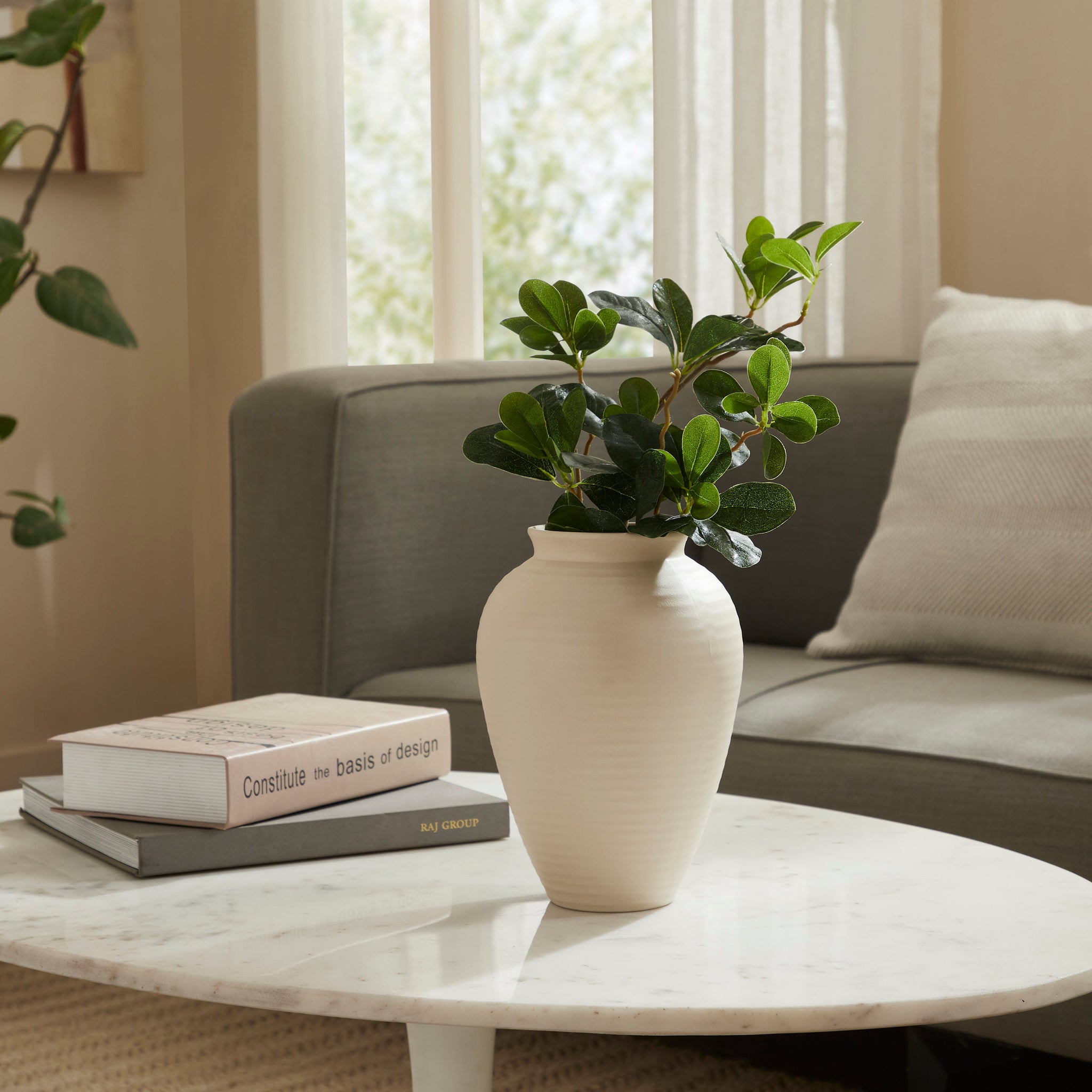 Hathor Vase by Renwil, styled with greenery on a coffee table in a living room